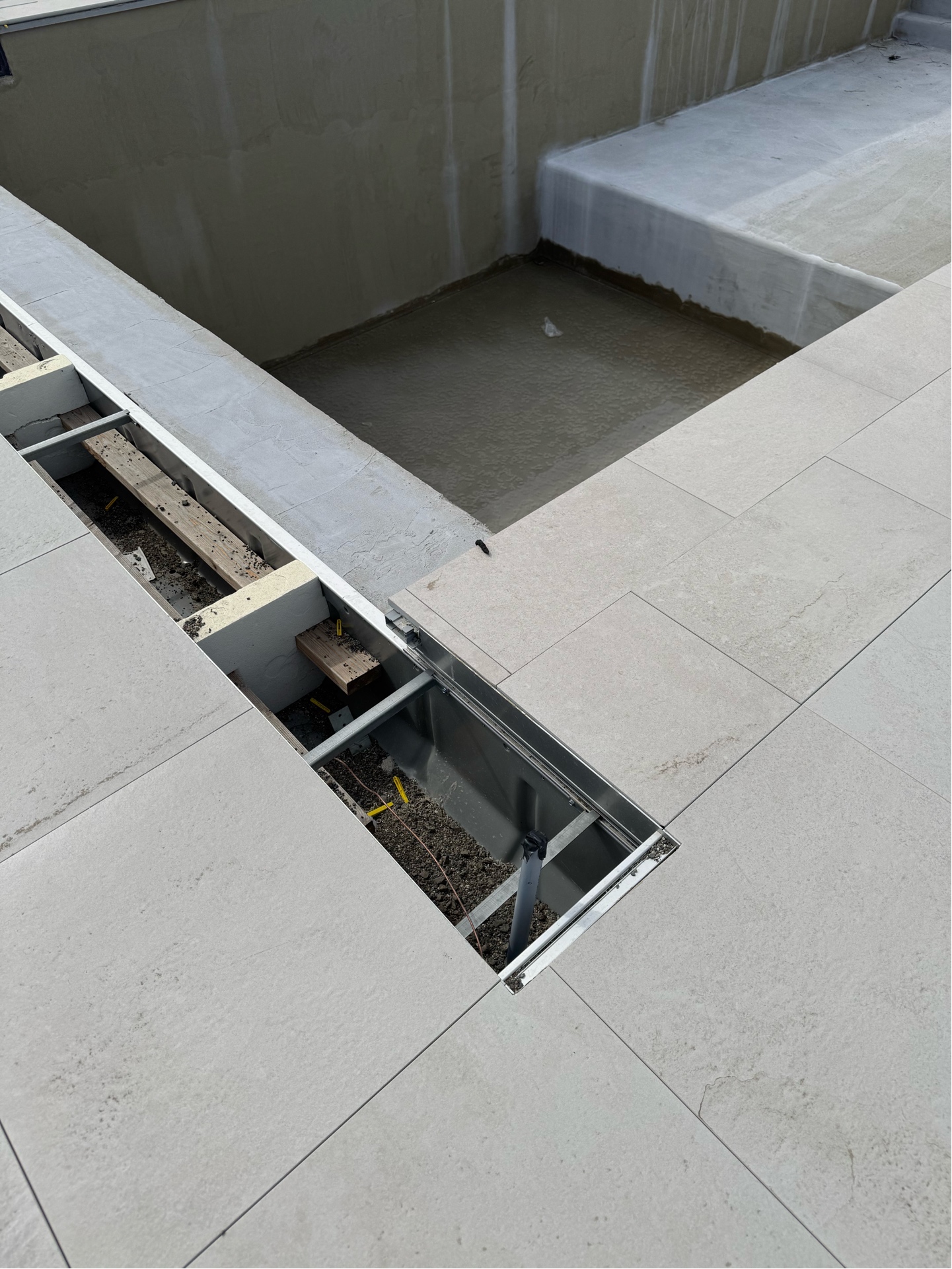Copper bonding tails stubbed through concrete pavers at pool edge