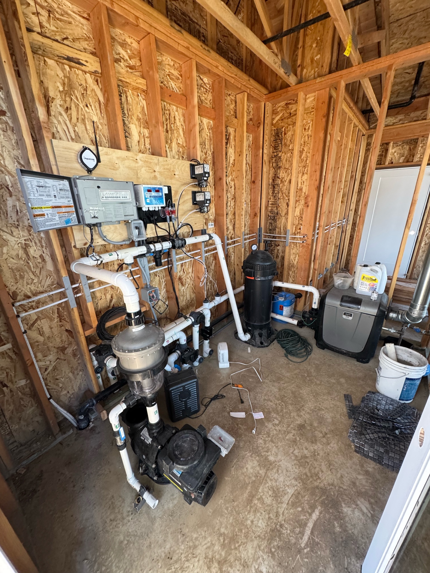 Pool equipment room with pumps, AquaLink controller, filter, and heater